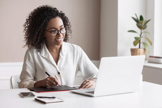 Mujer trabajando desde casa. Estudiante usando una laptop en su habitación